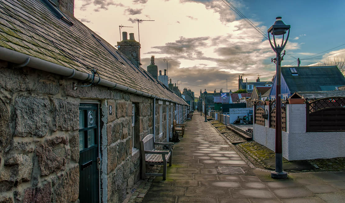 The historic fishing village of Footdee (Fittie) in Aberdeen, showing granite cottages and a narrow cobbled lane