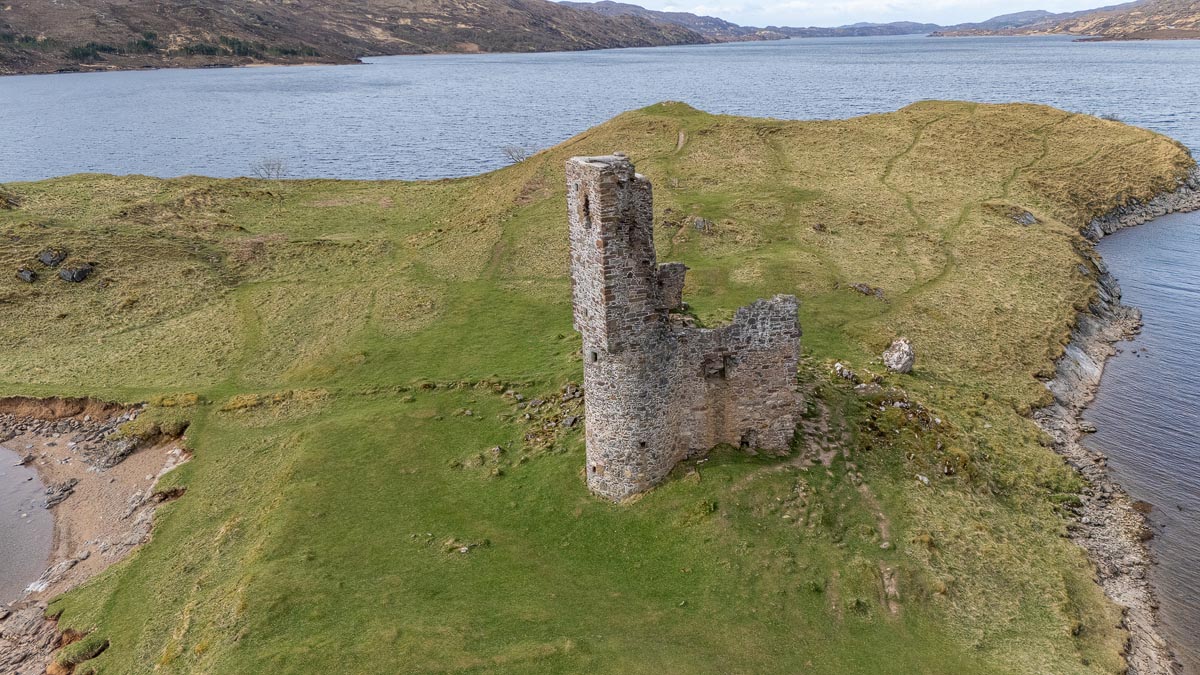 Aerial drone view showing the entire Ardvreck Castle promontory jutting into Loch Assynt