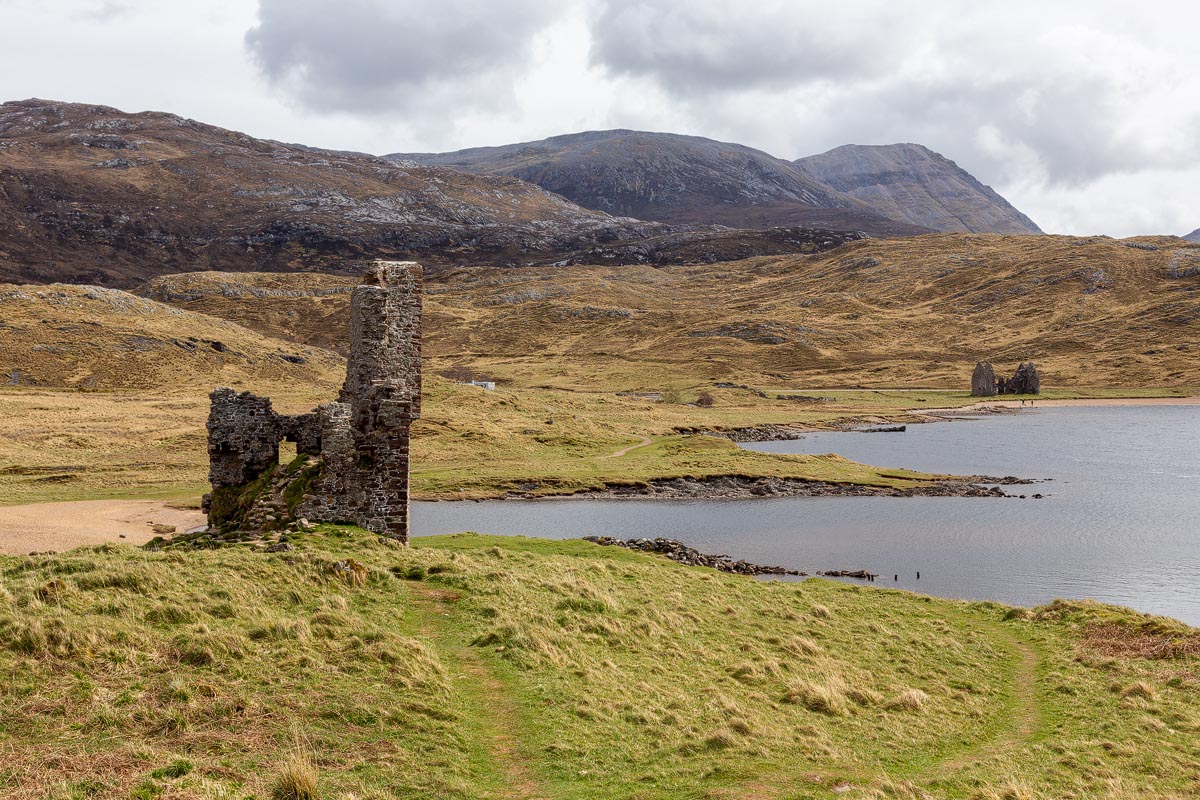 Ardvreck Castle ruins with Calda House visible across Loch Assynt and the Sutherland mountains beyond