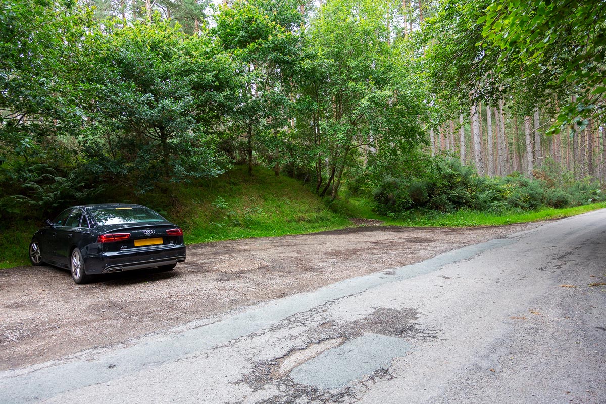 The small car park at Balblair Wood surrounded by Scots pine and birch trees near Golspie