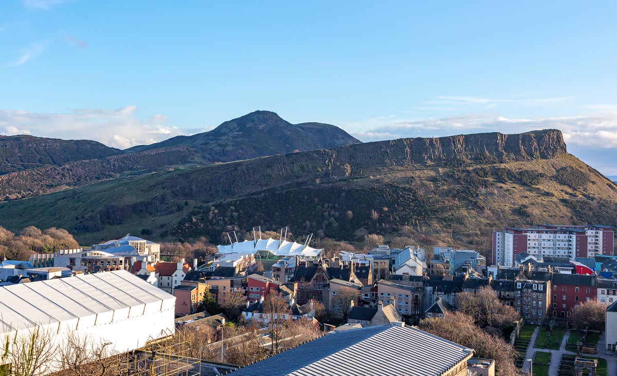 Arthur's Seat and Salisbury Crags rising above the Edinburgh skyline on a clear winter day with blue sky