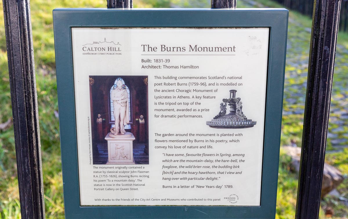 The Calton Hill interpretation panel at the Burns Monument, featuring a photograph of the original Flaxman marble statue and details about the monument's history