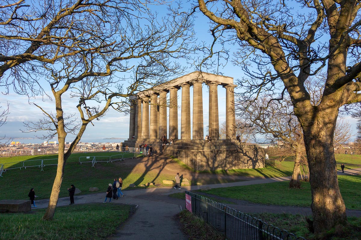 The National Monument on Calton Hill framed by bare winter trees, with the Firth of Forth visible beyond