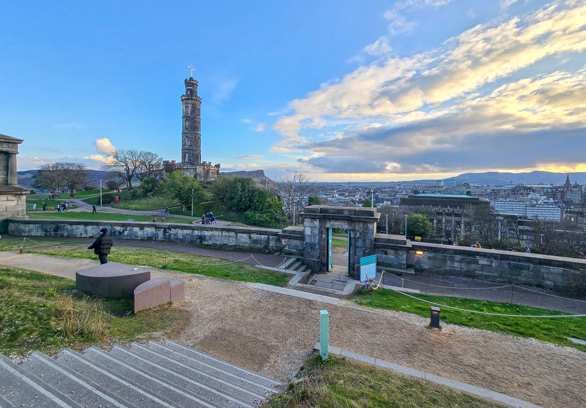 The Nelson Monument on Calton Hill with Edinburgh cityscape and dramatic sky beyond