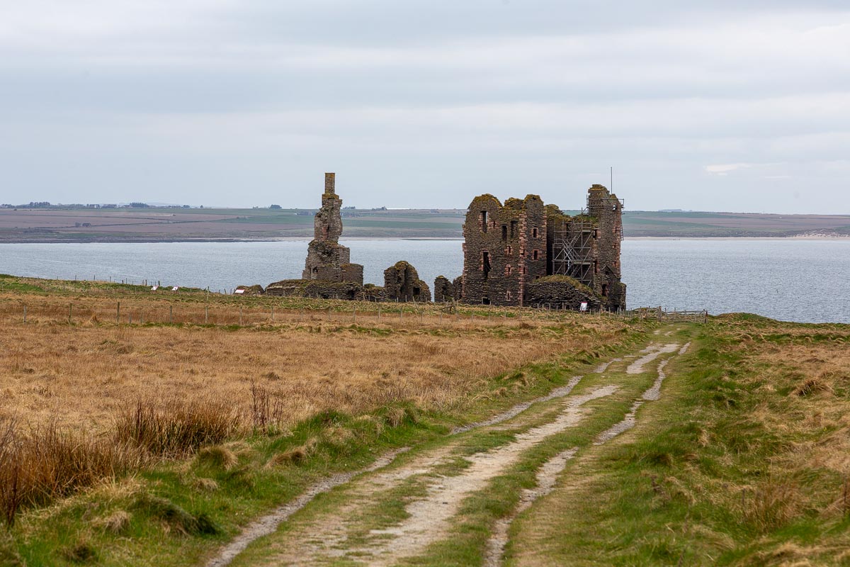 Castle Sinclair Girnigoe ruins seen from the approach path with Sinclair's Bay in the background