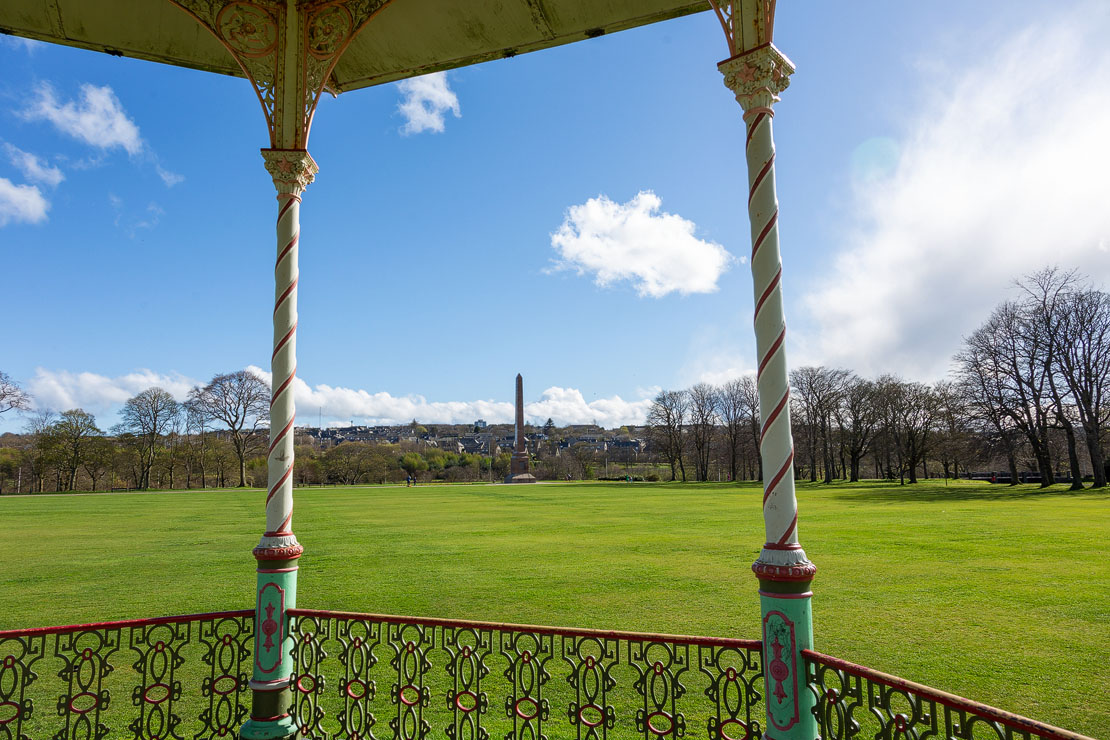 View from inside the Duthie Park bandstand looking out through the barley-sugar columns across the green towards the McGrigor Obelisk