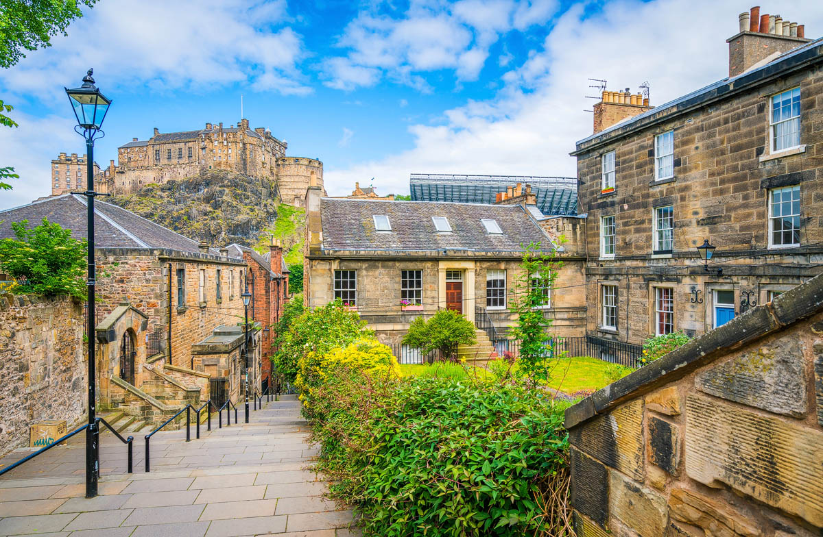 Edinburgh Castle viewed from the Vennel Steps near the Grassmarket with sandstone buildings and a traditional lamp post in the foreground