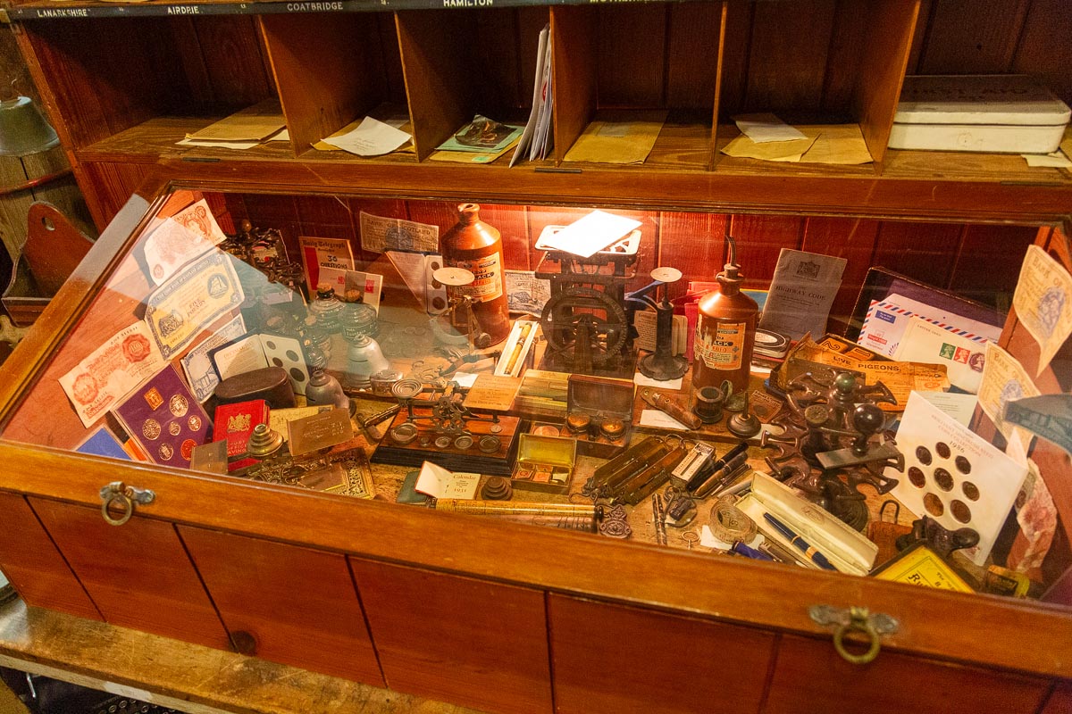 A recreated post office display with sorting pigeonholes, old banknotes, postal scales, and memorabilia
