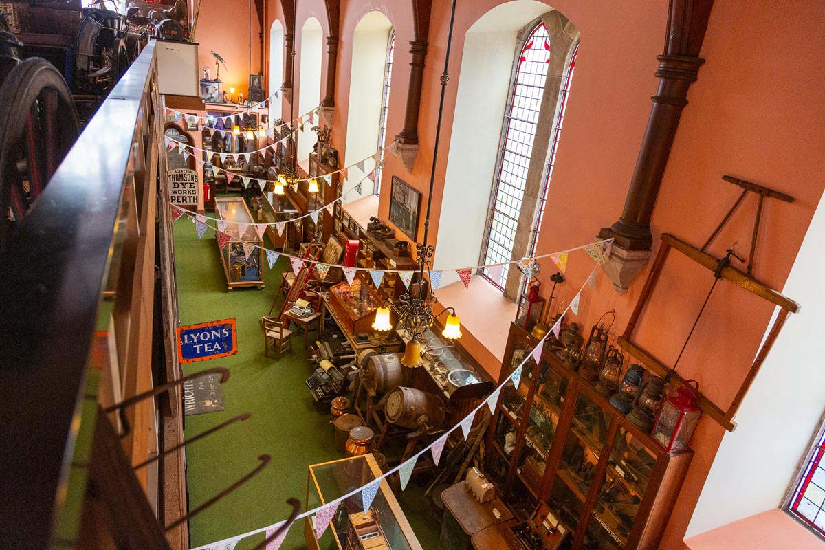 A view from the upper gallery looking down over the packed ground floor of the museum, decorated with bunting