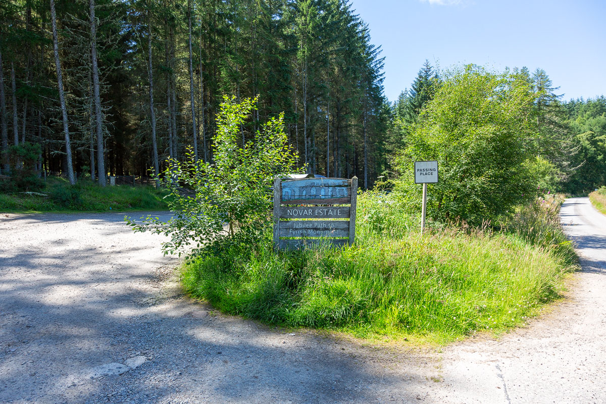 Weathered wooden Novar Estate sign at the roadside marking the start of the Jubilee Path to Fyrish Monument