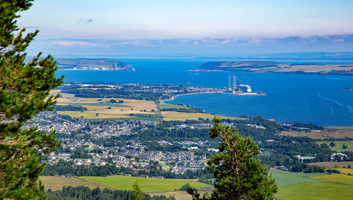 View down over Alness and Invergordon with the Cromarty Firth, port and oil rigs, and the Black Isle beyond