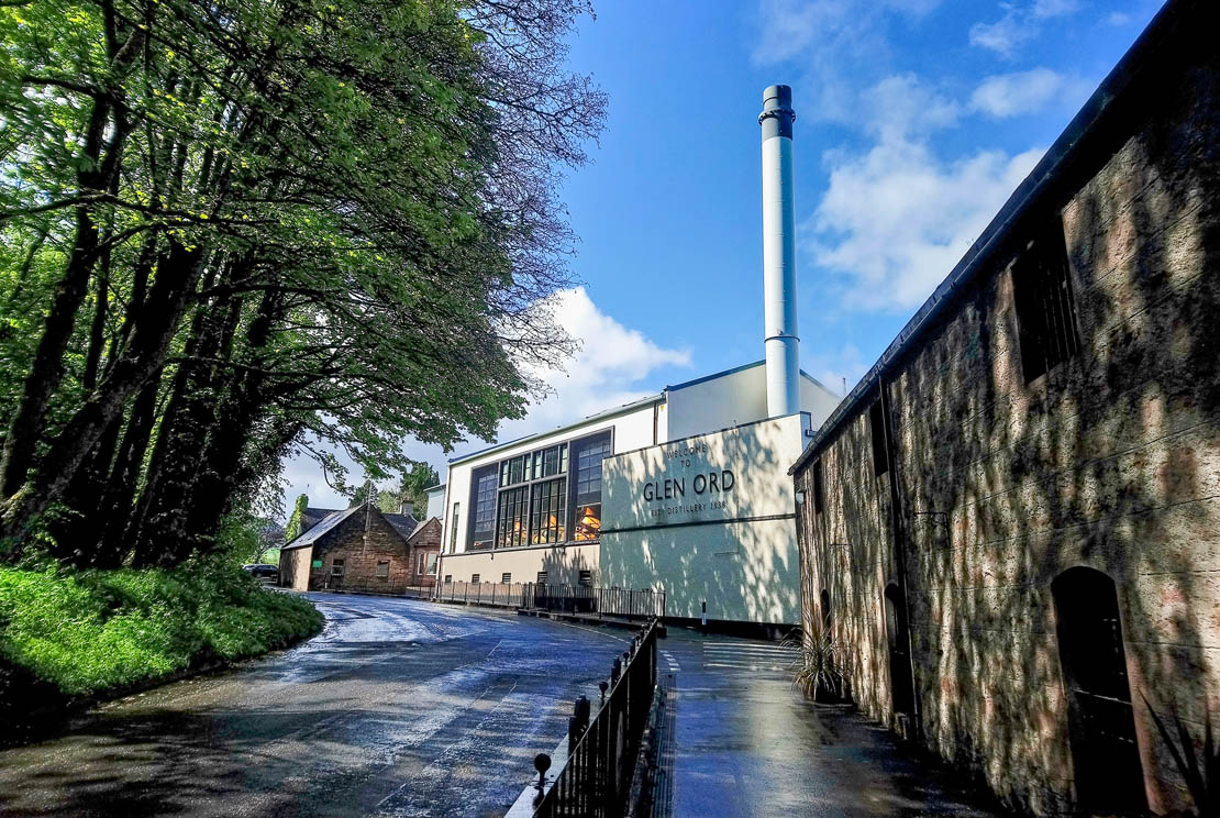 The exterior of Glen Ord Distillery near Muir of Ord showing the modern stillhouse with Welcome to Glen Ord signage
