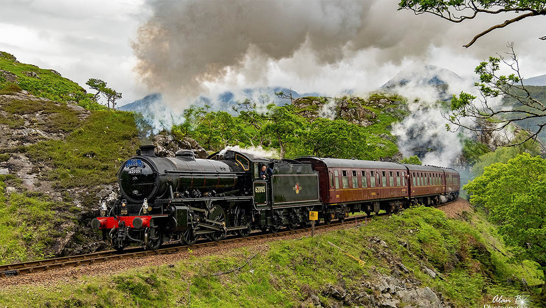 The Glenfinnan Viaduct with steam train crossing, known as the Harry Potter Bridge in the Scottish Highlands