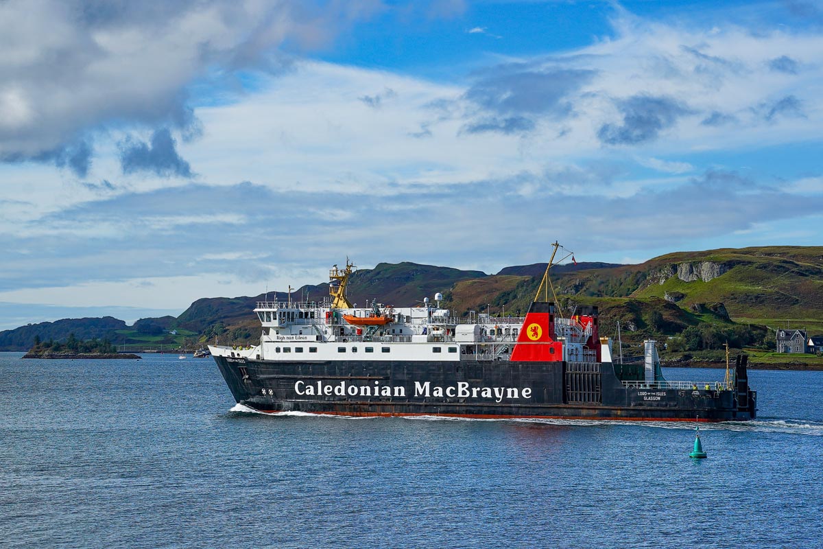 A Caledonian MacBrayne ferry sailing towards the Isle of Mull with the Scottish coastline behind