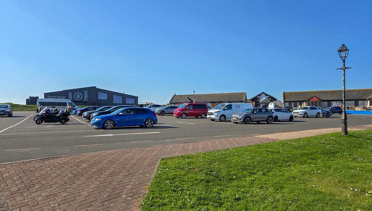 The spacious car park at John o' Groats with the 8 Doors Distillery and gift shops in the background