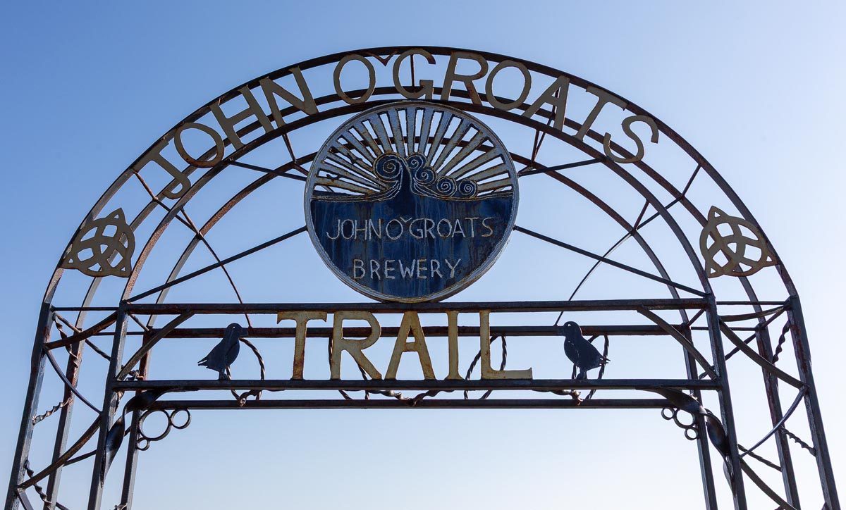 The decorative wrought iron John o' Groats Trail arch featuring the brewery logo and Celtic knotwork