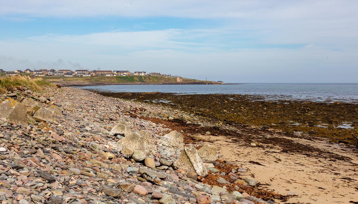The rocky northern end of Keiss Beach looking towards Keiss village and harbour