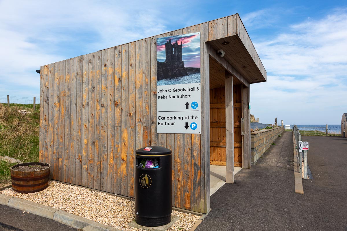 Wooden information shelter with signage for the John O Groats Trail and directions to Keiss Castle