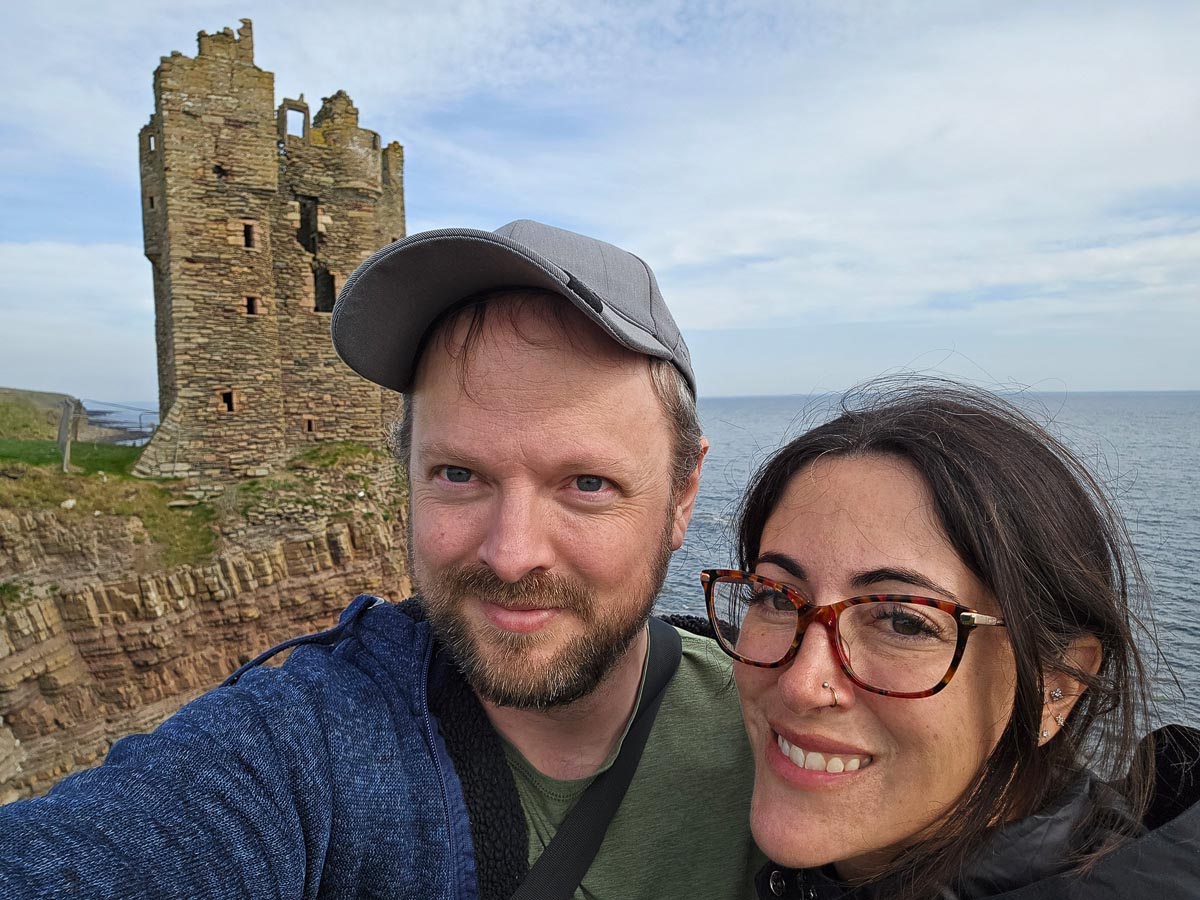 Chris and Janette taking a selfie with Old Keiss Castle and the North Sea behind them