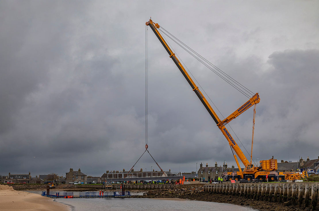 Crane lifting bridge sections into place for the new Lossiemouth footbridge.