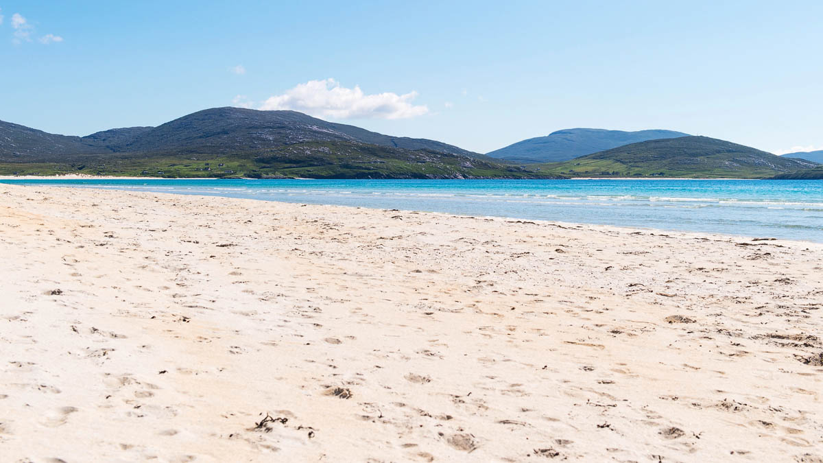 Luskentyre Beach on the Isle of Harris with white sand and turquoise water backed by mountains