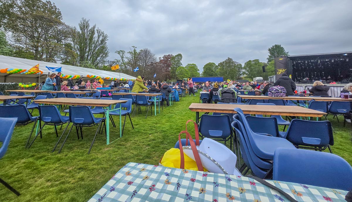 VIP table seating at MacMoray with blue chairs, wooden tables and balloon decorations, stage in distance