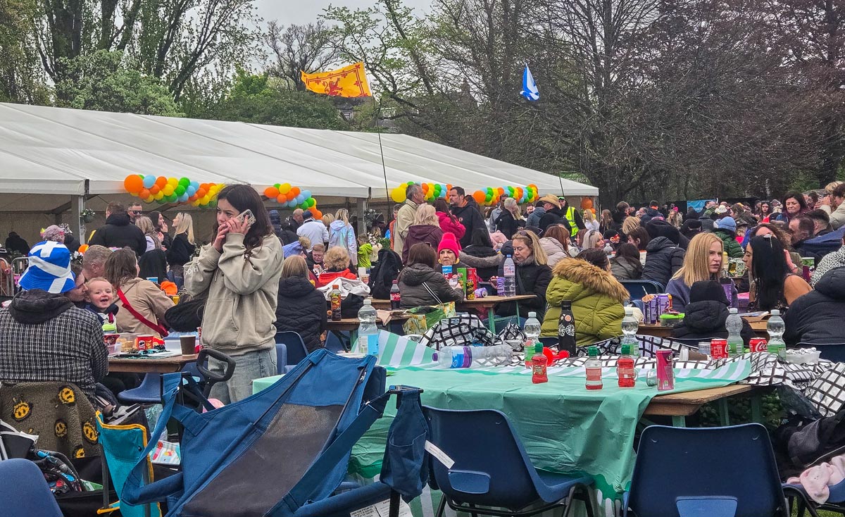 Crowded VIP marquee at MacMoray with families seated at tables and Scottish flags flying