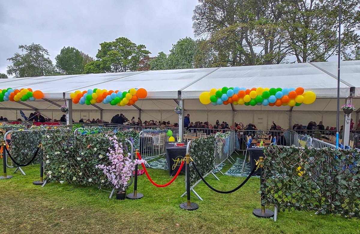 VIP marquee at MacMoray decorated with balloon swags, ivy panels and red velvet rope barriers