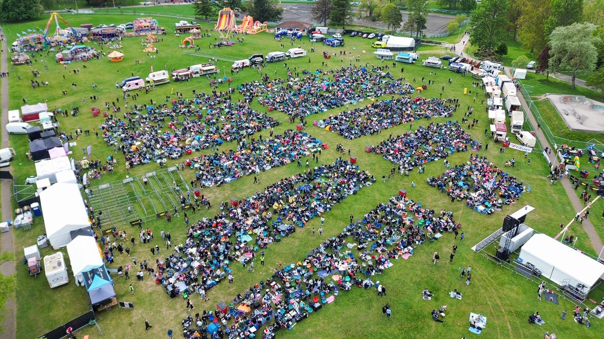 Drone view of Stage Two crowd at MacMoray with funfair visible at the top of the frame