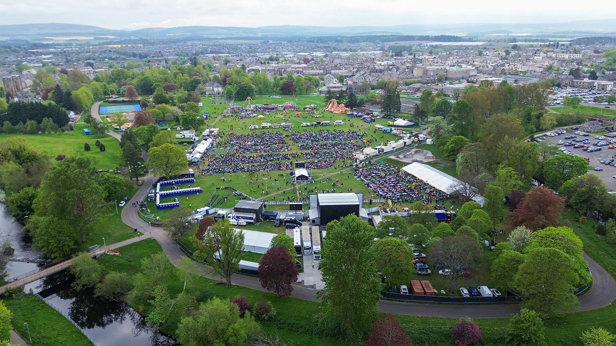 Drone view of MacMoray Festival in Cooper Park, Elgin, with the River Lossie and Elgin town in the background