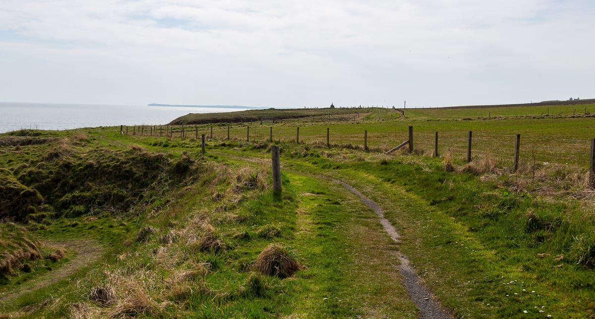 The coastal footpath leading from the car park towards Nybster Broch with the North Sea on the left and Mervyn’s Tower visible in the distance