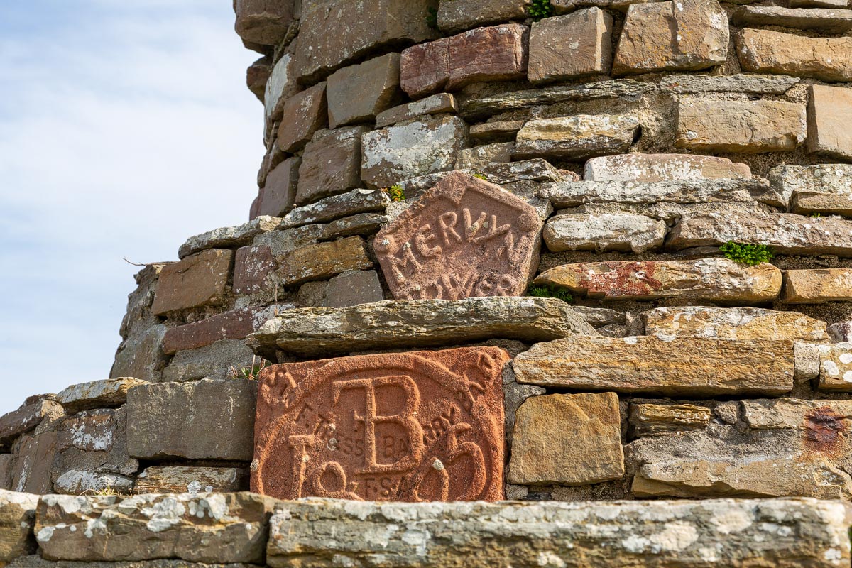 Close-up of carved red sandstone plaques on Mervyn’s Tower showing inscriptions for Mervyn Tower and Sir F Tress Barry Bart