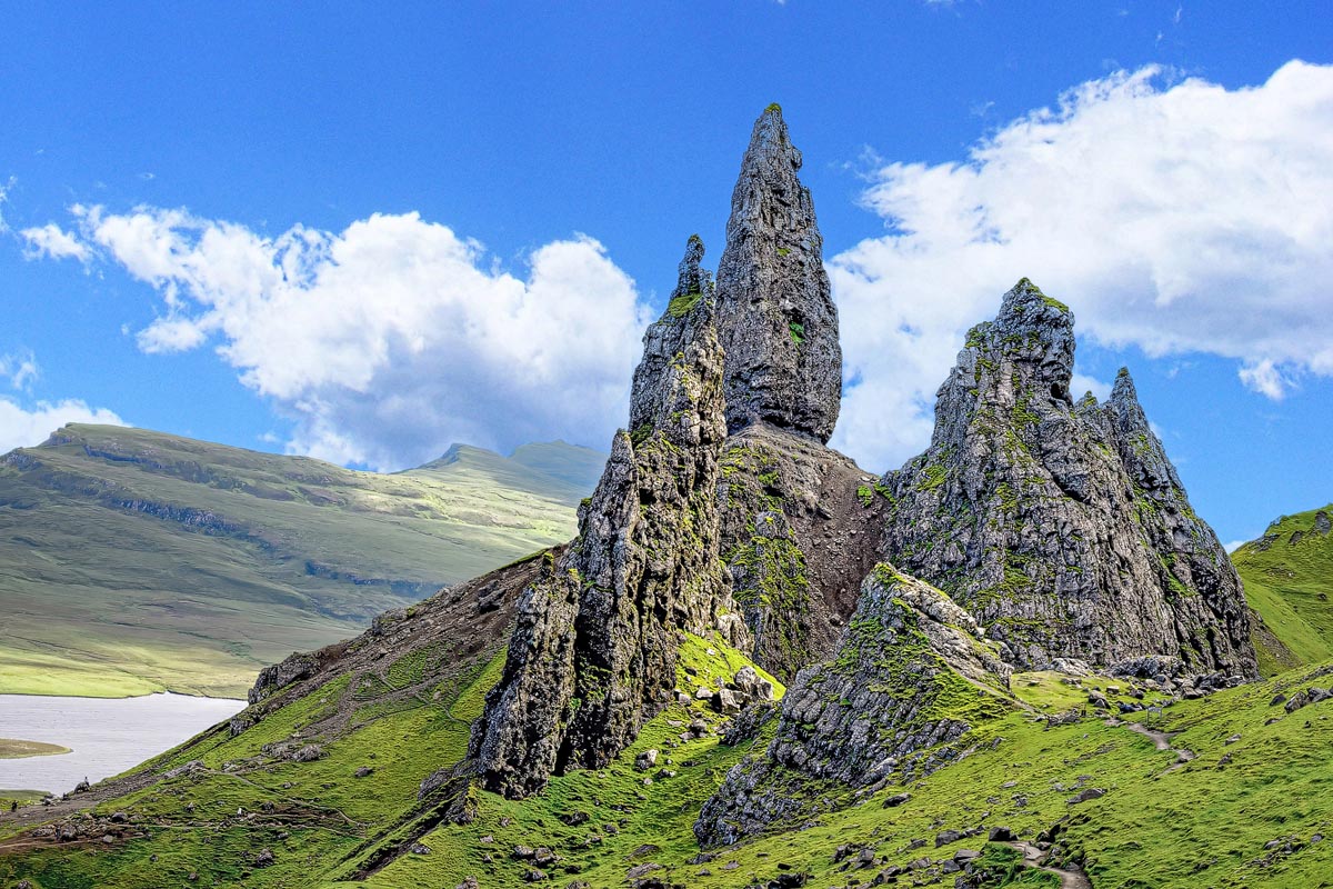 The Old Man of Storr rock formation rising from the mist on the Isle of Skye with the loch visible below