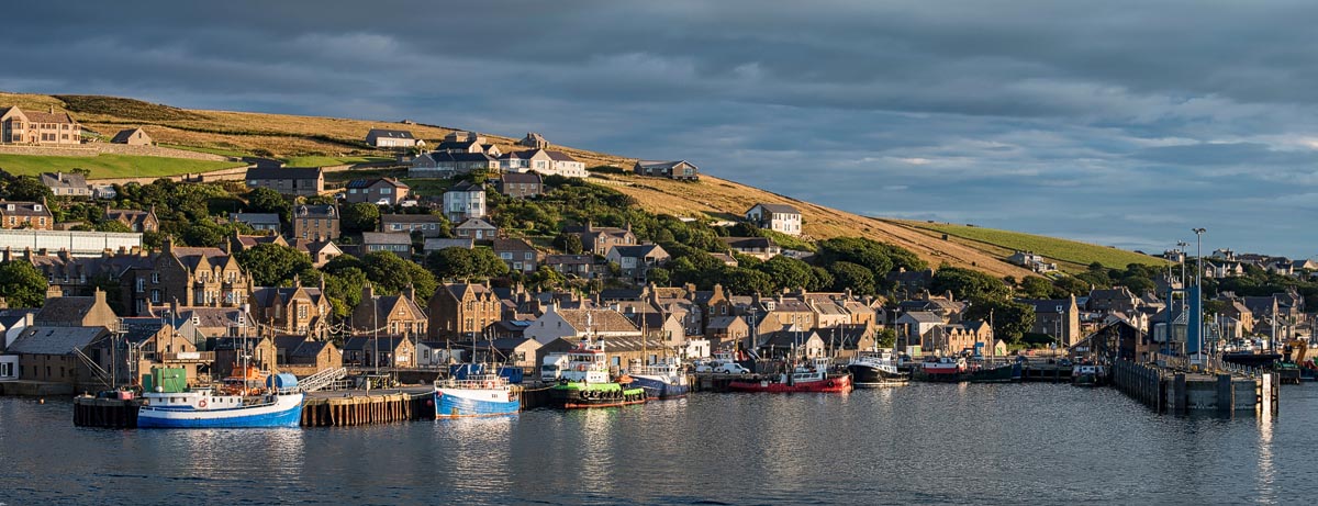 Stone buildings lining the harbourfront in Stromness, Orkney