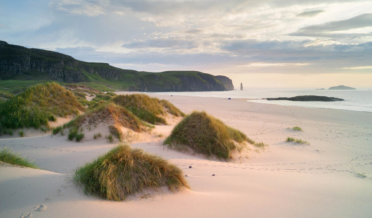 Sandwood Bay in Sutherland with sand dunes, dramatic cliffs and Am Buachaille sea stack