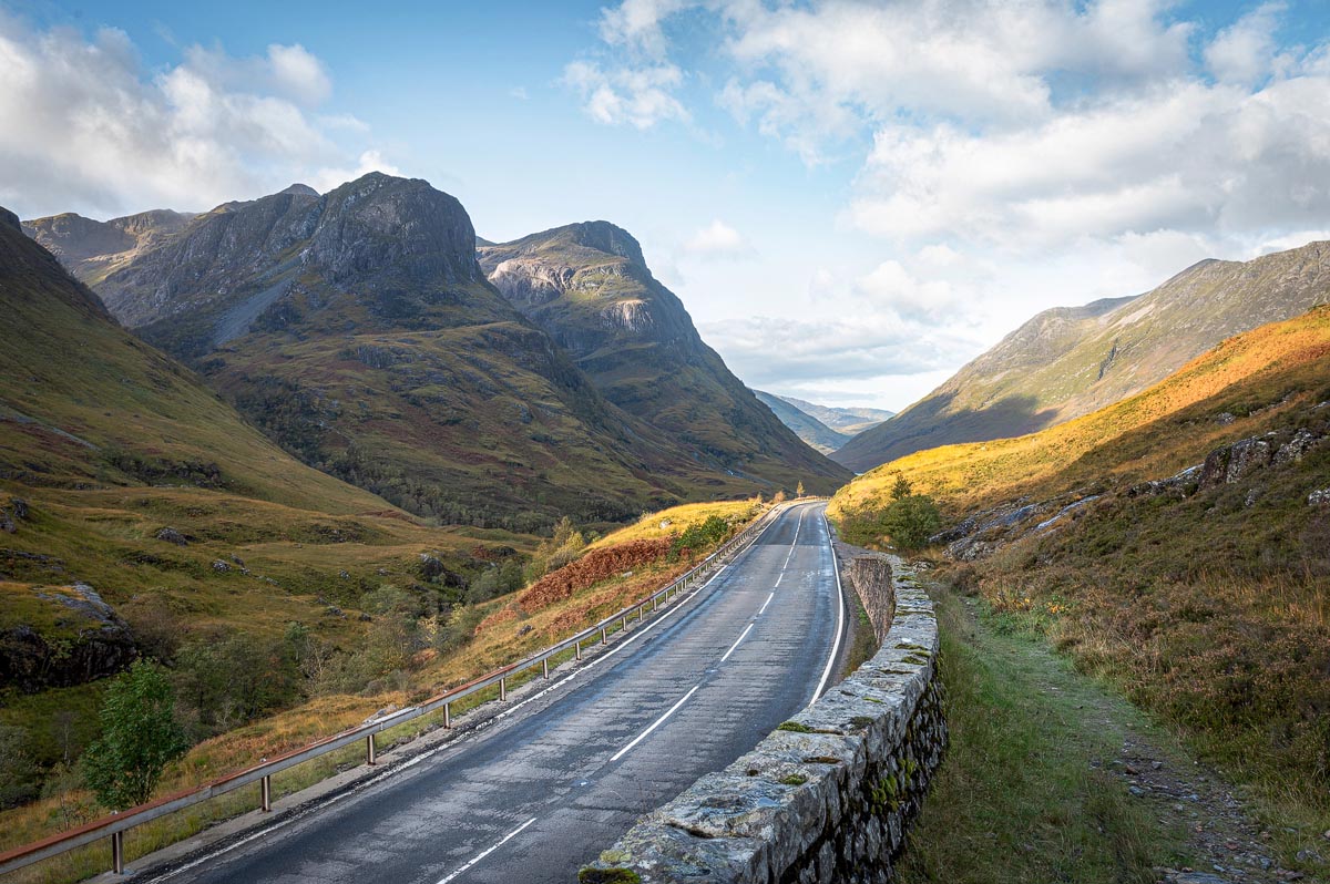 The A82 road sweeping through Glencoe in autumn with the mountains rising steeply on either side