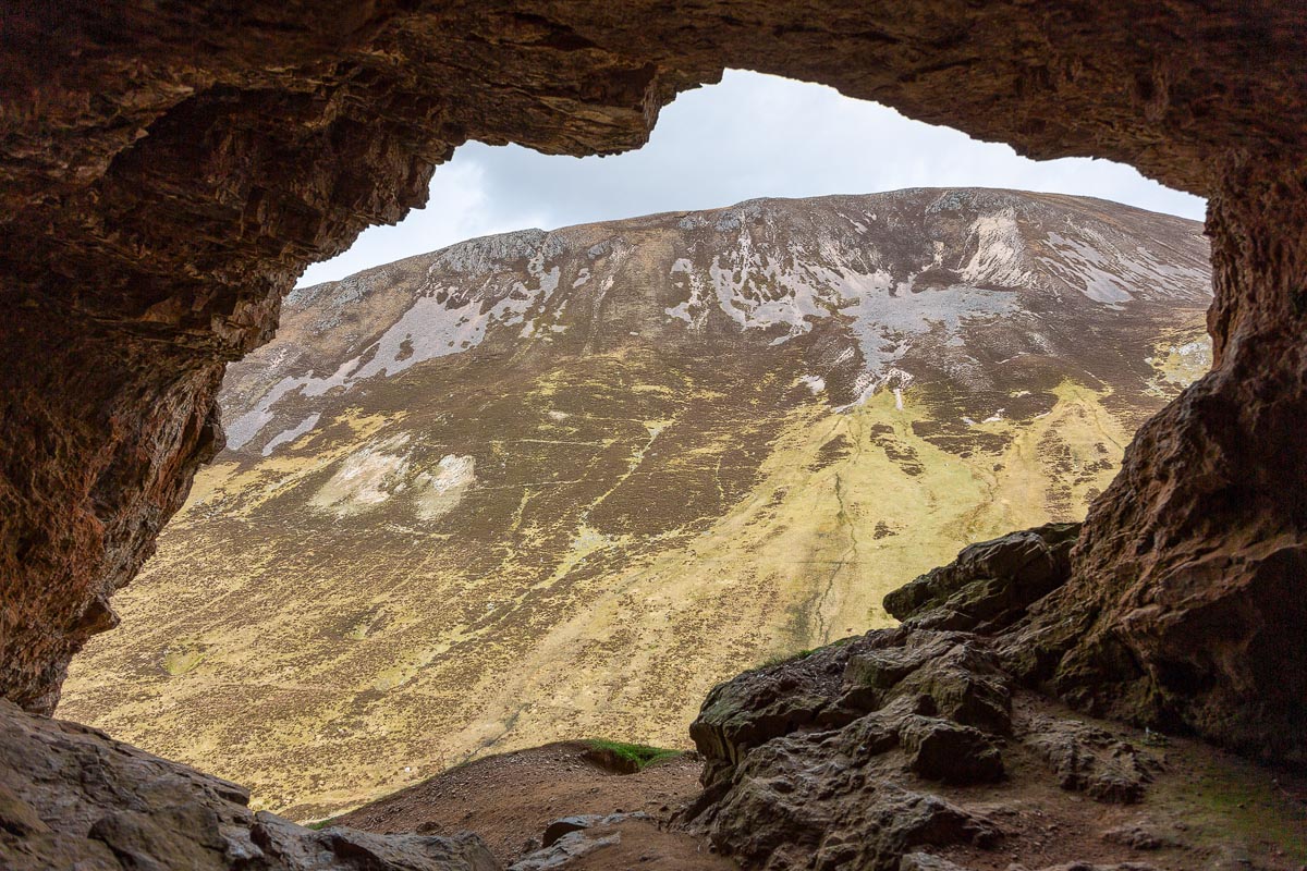 View looking out from inside a Bone Cave with the hillside framed by the cave mouth