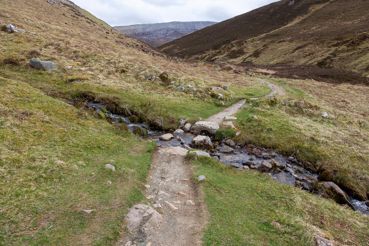 The walking path following a small stream through the narrowing Allt nan Uamh valley