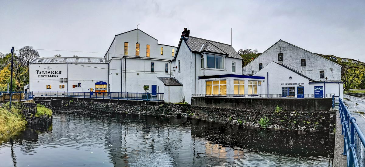 The white buildings of Talisker Distillery beside the water at Carbost on the Isle of Skye