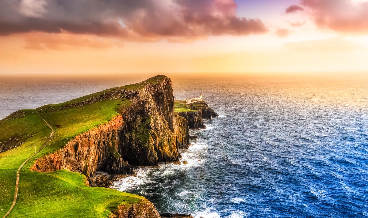 Neist Point Lighthouse perched on dramatic sea cliffs at the westernmost point of the Isle of Skye at sunset