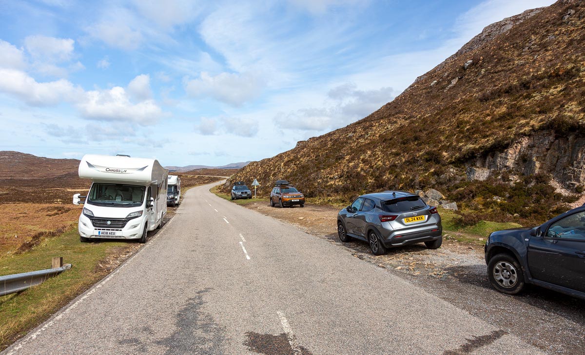Roadside parking along the A894 near Wailing Widow Falls with cars and a motorhome