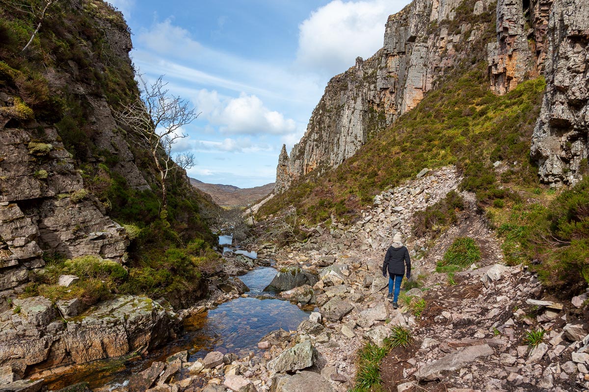 Walking back through the gorge from Wailing Widow Falls with the rock pinnacle and blue sky