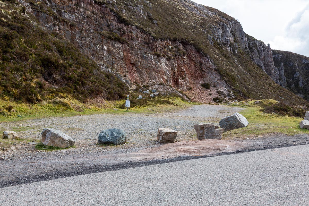 The boulder-lined layby entrance near Wailing Widow Falls with exposed rock face