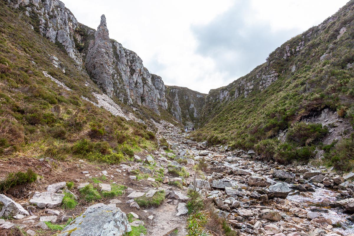 The dramatic rock spire towering above the gorge path to Wailing Widow Falls