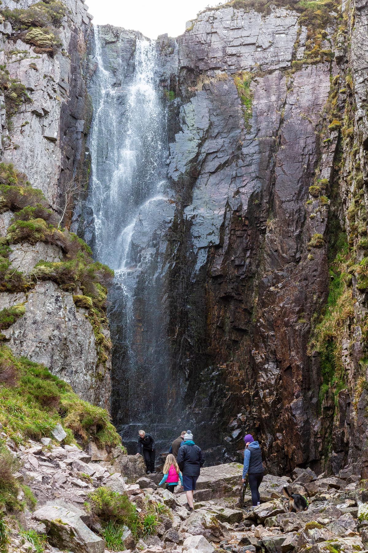 Visitors standing at the base of Wailing Widow Falls looking up at the cascading water